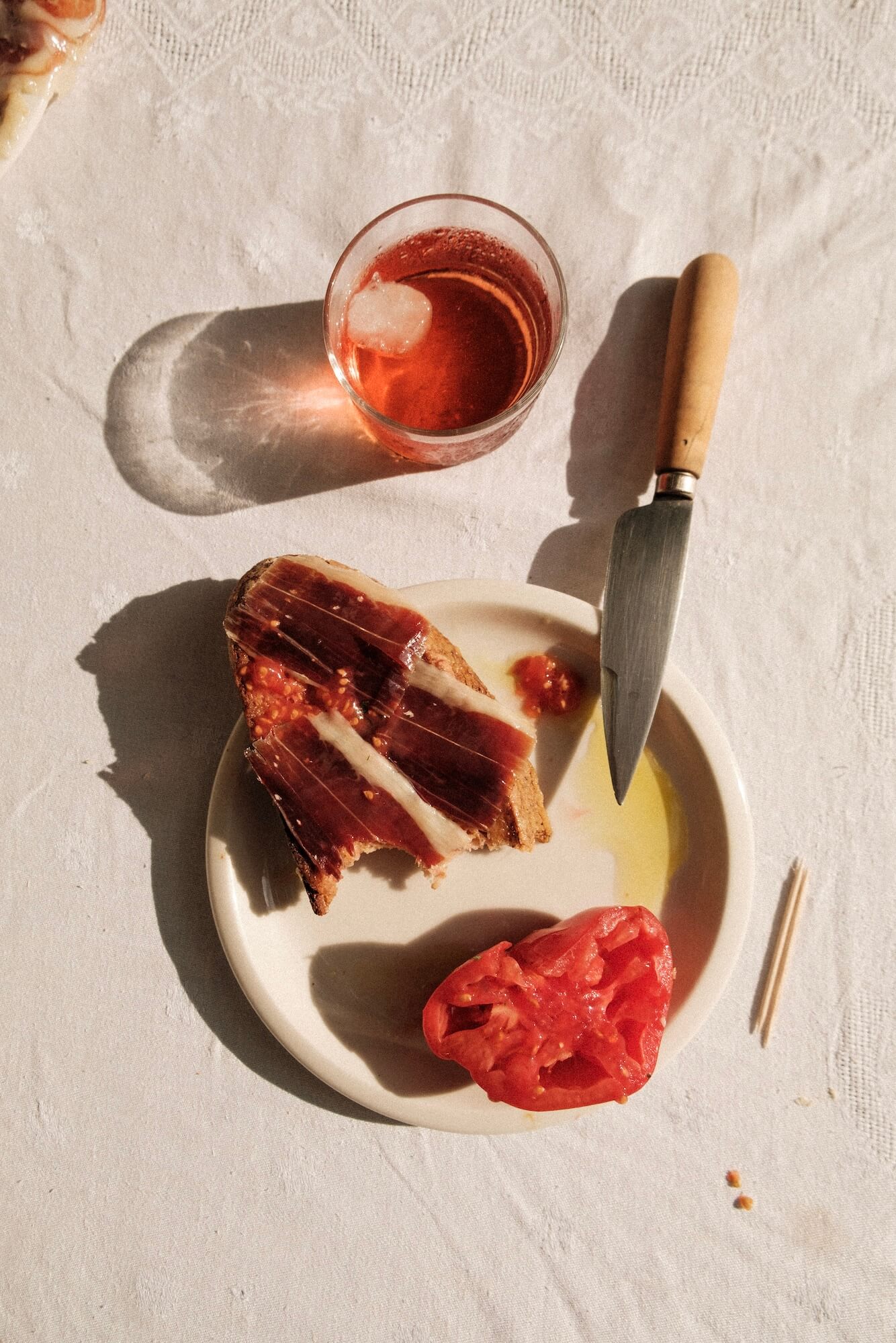 un pain toasté frotté avec de la tomate et des tranches de jambon LOLO dessus